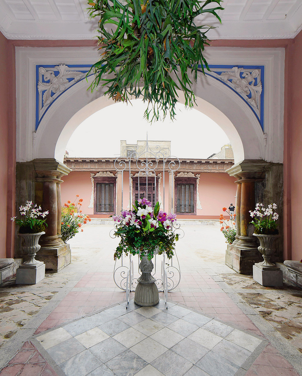 <span>Saguão - Manolo Arias Cucho e Ekaterina Zakharova. Esta conexão entre a rua e o pátio guarda muito da arquitetura espanhola. Ele é repleto de sentidos: espaço de encontro, de espera, um lugar por onde todos passam e a transição para a intimidade familiar. Ele também é a primeira impressão da casa para o visitante, por isso sua decoração é cuidadosa, reunindo belos vasos de flores e um pórtico desenhado com entalhes.</span>