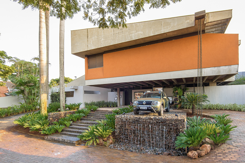 Para os profissionais da CASACOR Mato Grosso do Sul 2016, o restauro da casa sede foi inspiração para criação de seus projetos na mostra. O evento ocorreu em uma tradicional residência com uma linha modernista, projetada na década de 80 pelo renomado arquiteto Rubens Gil de Camillo (1934-2000). Ele se preocupava em criar uma linguagem arquitetônica característica do estado, adequado ao modo de vida da população e dos aspectos físicos e bioclimático. O imóvel tem 1,8 mil m² de área construída em um terreno de 2 mil m². A casa tem uma ótima localização, um projeto audacioso com concretos aparentes que estimulou a criatividade do time de profissionais da mostra. A proprietária, Isolina Dibo permitiu todo o restauro e ficou feliz com o resultado. “Rubens Gil de Camillo se empenhou muito para fazer a casa, nós debatemos bastante sobre o perfil da construção, pois era um projeto muito caro e ousado para a época, mas ele nos convenceu e depois ficamos muito felizes com o resultado”, contou.