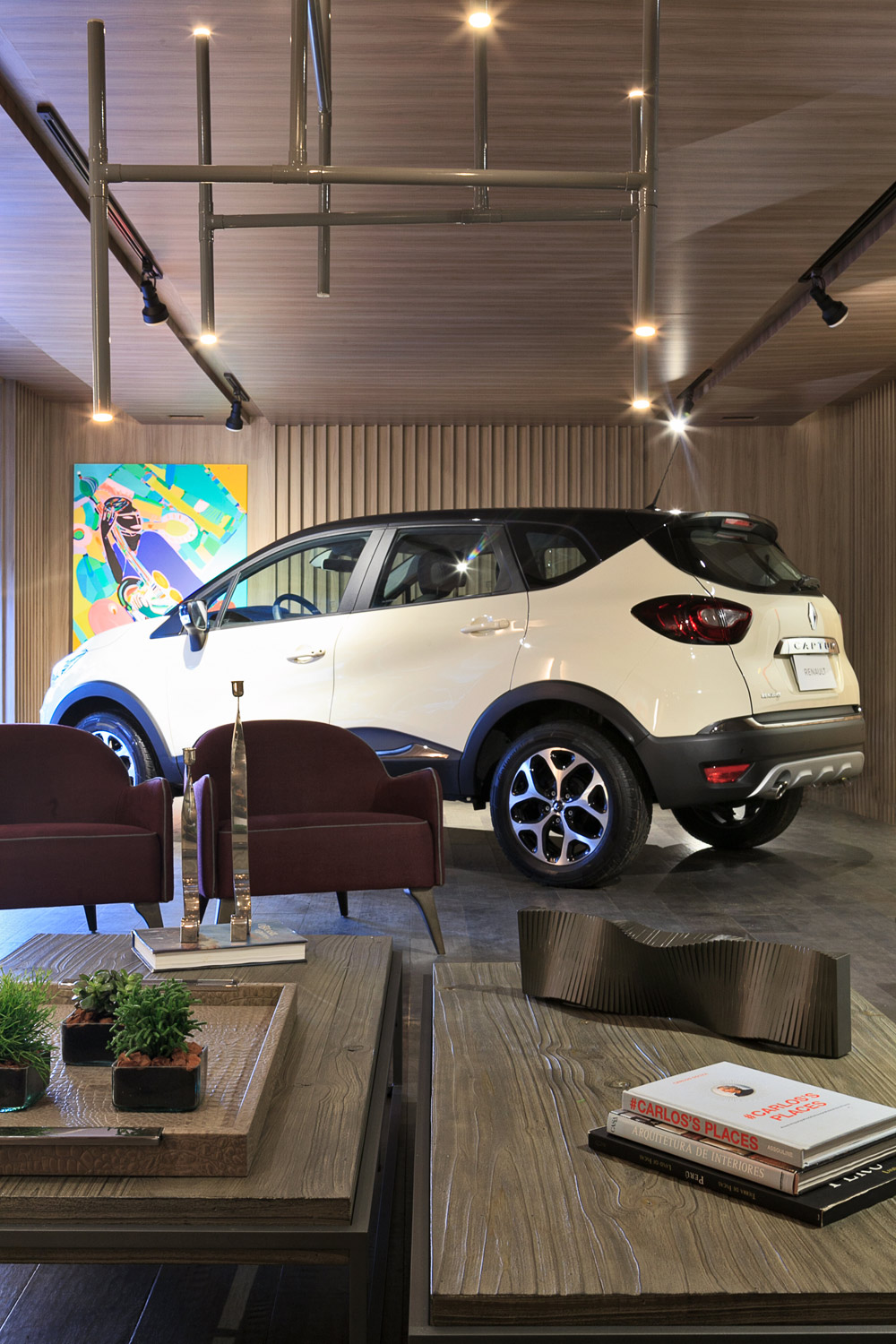 Garagem Renault - Margit Soares. A alternância de profundidades nos revestimentos e as tonalidades amadeiradas deixam em primeiro plano as linhas marcantes e fluidas do Renault Captur.