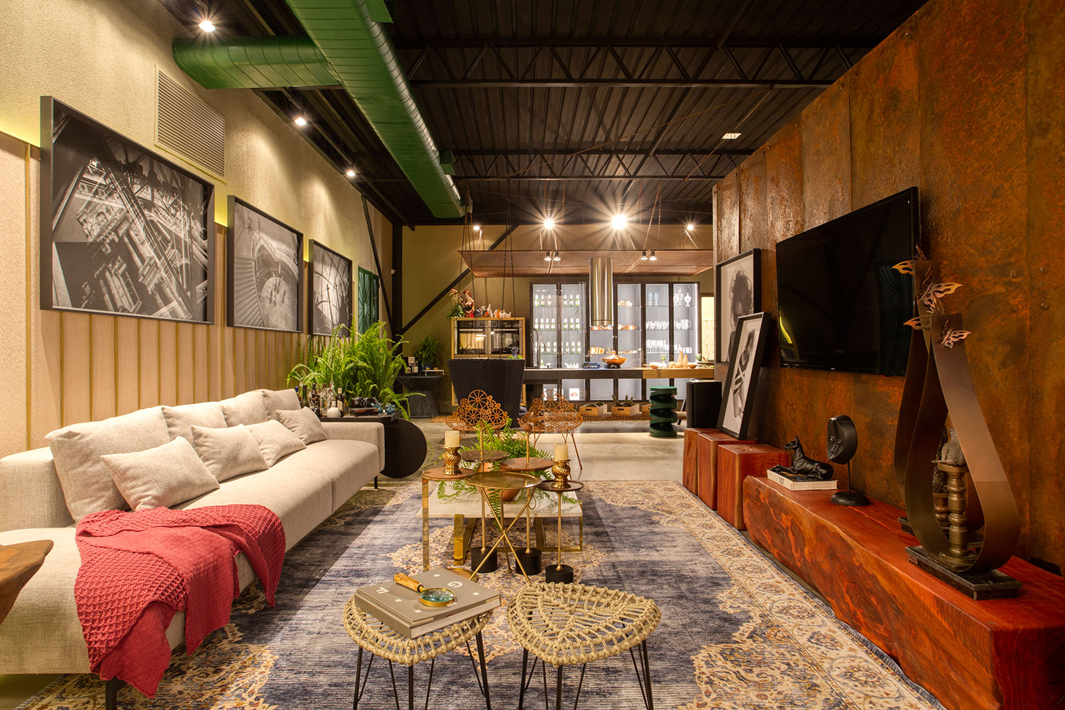 Loft - Artur Moraes, Joana Moraes e Miralba Moraes. Lofts são espaços sem divisórias, onde sutilezas demarcam cada ambiente. É o que se encontra neste projeto de 117 m² inspirado na sustentabilidade, que reaproveita materiais garimpados em um ferro velho. Uma parede foi produzida em chapa de ferro e isola o quarto da sala, garantindo privacidade. Nela, um stain fosco foi aplicado para que a ferrugem não avance. Ao fundo, na cozinha, a bancada F53 da Florense tem mais de 4 metros de extensão.