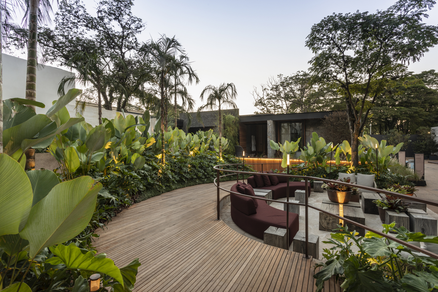 CASACOR São Paulo 2019. Jardim Elementar - Kalil Ferre Paisagismo. O Jardim Elementar tem como ponto de partida a interação entre o homem e a natureza. Para este projeto, que é responsável pela integração de três ambientes da mostra, os elementos naturais são determinantes: pedra, fogo, madeira e vegetação são as estrelas. As linhas orgânicas aparecem ainda em um espaço lúdico, criado com três balanças assinadas pelo renomado designer brasileiro Sérgio Matos.