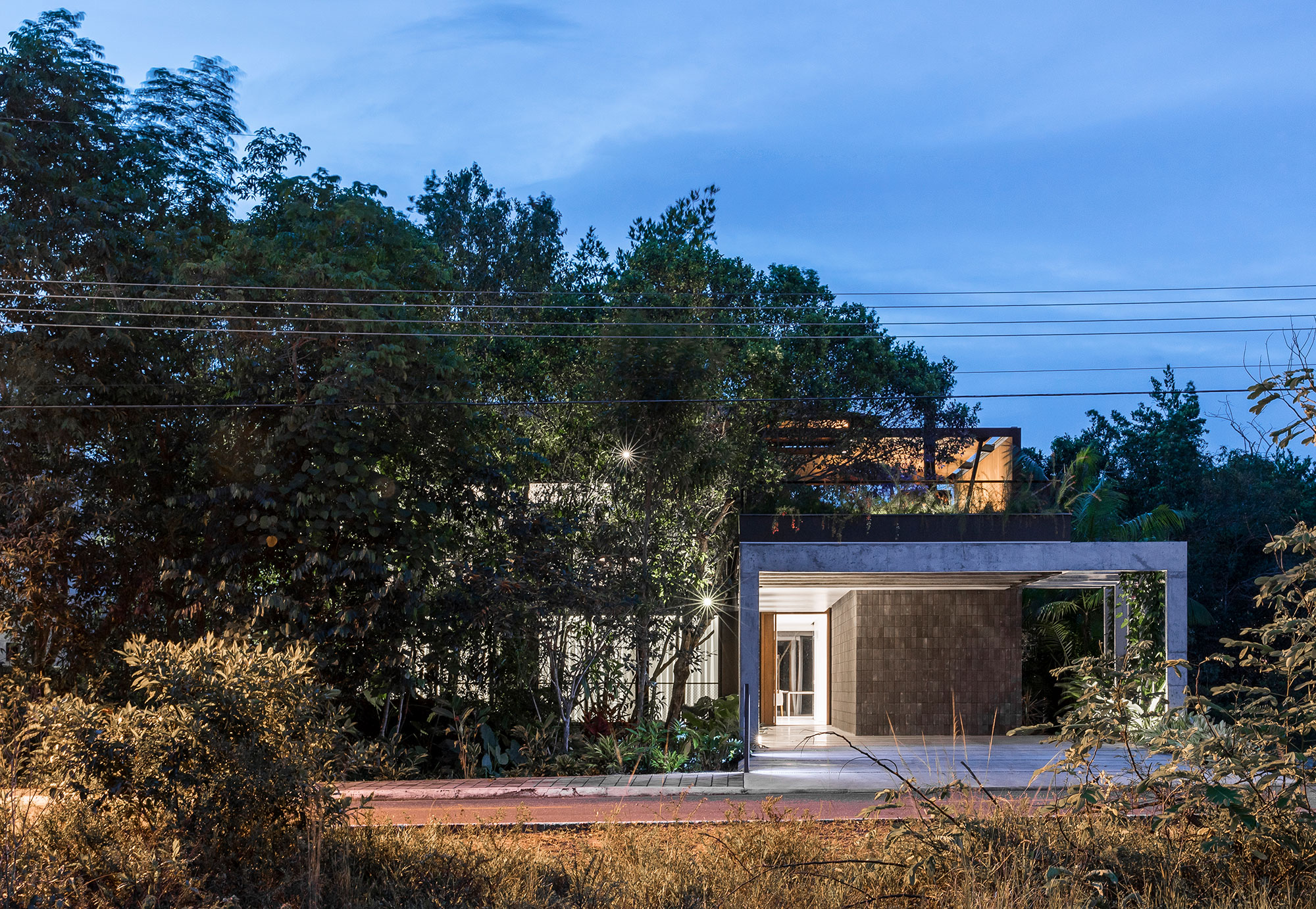 Fachada da casa Campinarana: as árvores funcionam como barreira visual da fachada.