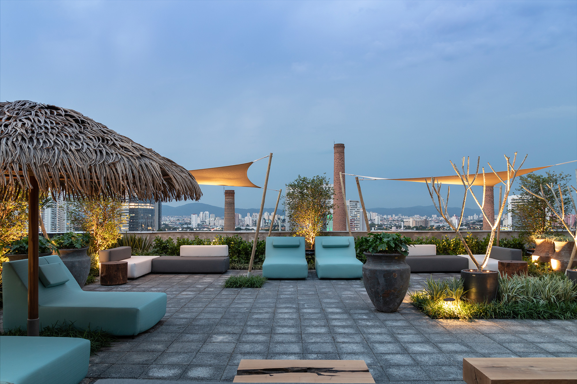 Catê Poli e João Jadão - Rooftop CASACOR. Inspirado nos beach clubs rústicos de Mykonos, Tulum e Trancoso, o espaço de 224 m² nasce para trazer um clima de férias de verão pós-pandemia. “Criamos um lugar para o visitante usar, descansar, curtir o céu, admirar a vista e ter um pouco da sensação de esperança de que a pandemia está acabando”, revela a arquiteta paisagista Catê Poli, que assina o ambiente com o paisagista João Jadão. A dupla optou por espécies de plantas adaptadas ao clima e que não exigem muita água além disso, pós o evento, todos os materiais serão reaproveitados integralmente.