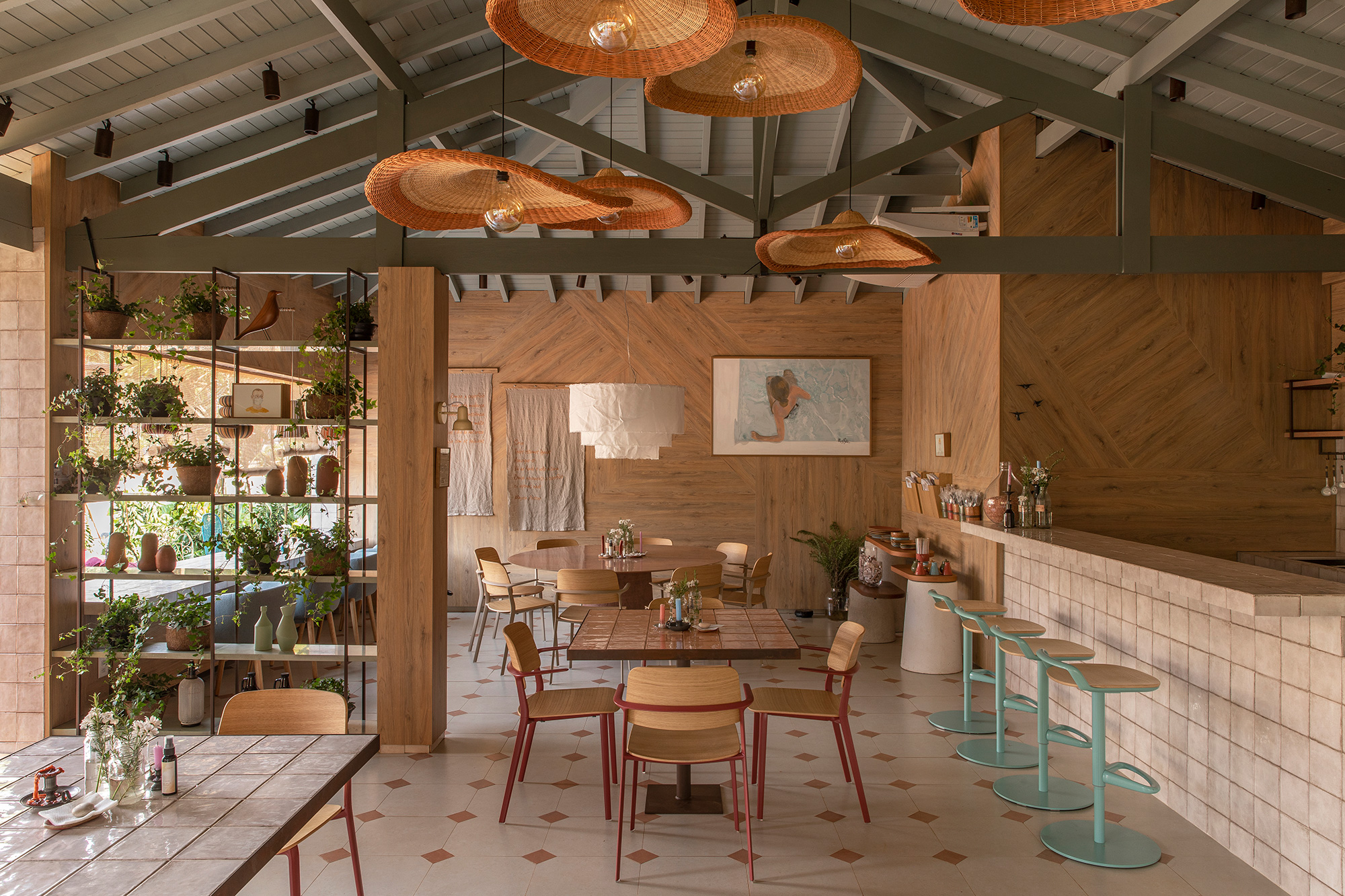 Cacau Ribeiro Interiores - Restaurante Arauco. Estimular a tão esperada convivência no pós-pandemia foi a inspiração para a profissional criar um espaço que remete ao simples, ao artesanal, à volta às origens. Esses conceitos se revelam por meio da composição entre cores, texturas e revestimentos. E de uma cuidadosa curadoria de elementos como peças bordadas à mão, tramas, pendentes de palha e arandelas de rolos de papel desenvolvidas pela designer em parceria com Roberta Faustini – conjunto que confere uma iluminação acolhedora.