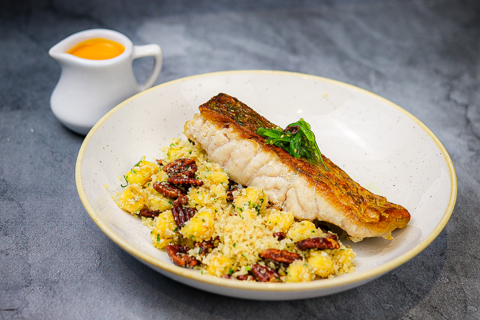 Peixe do dia com farofa de banana, noz pecan caramelizada e molho de moqueca capixaba